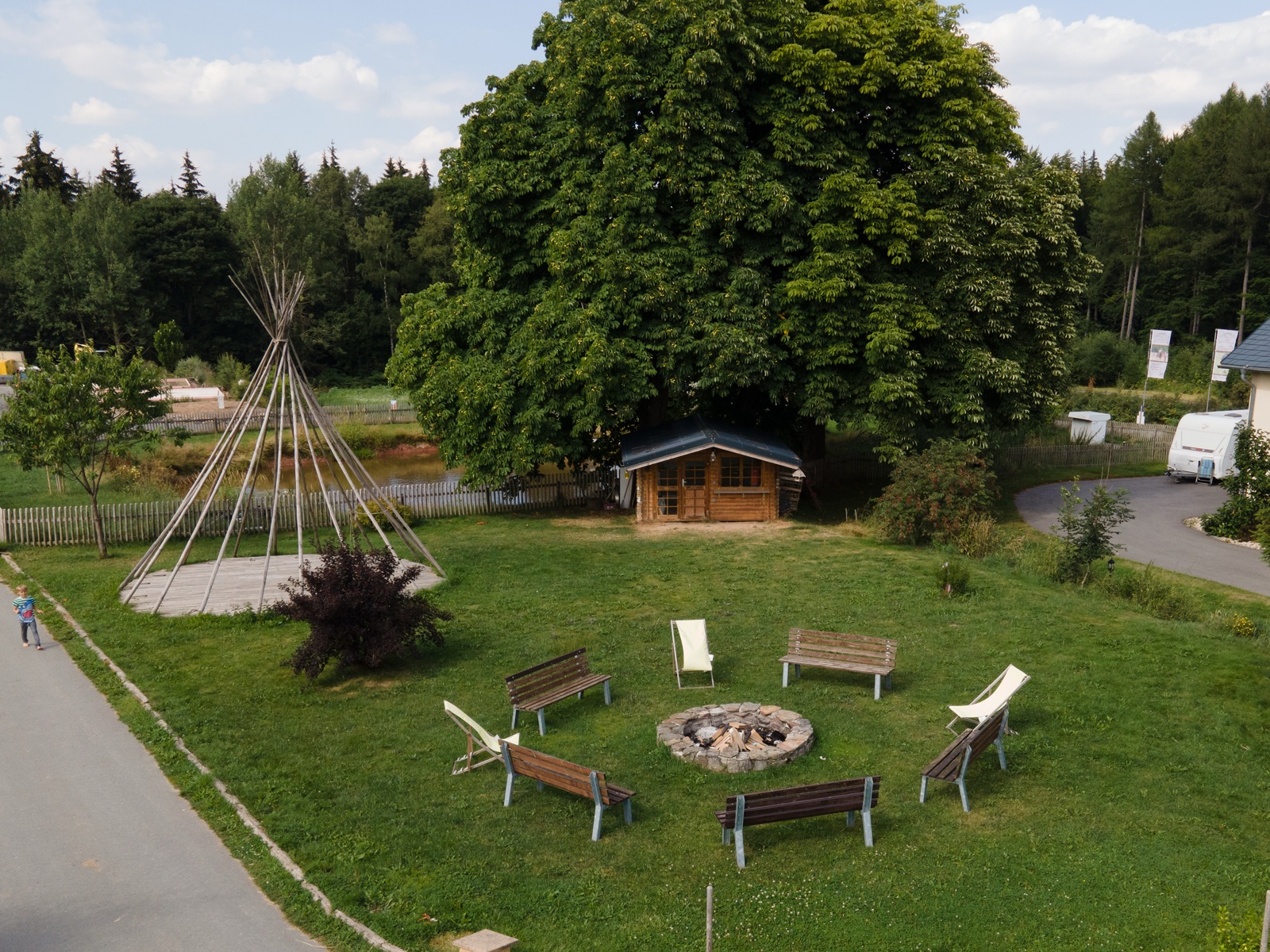 Feuerstelle mit Bänken, Tipi und Kastanie