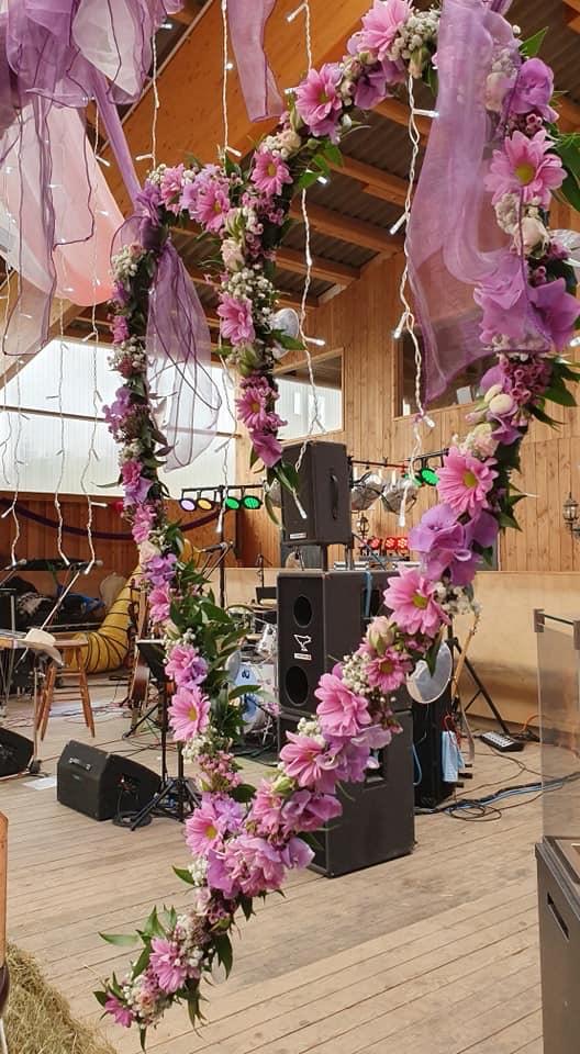 Herzbogen aus rosa Blumen vor der Bühne in der Reithalle