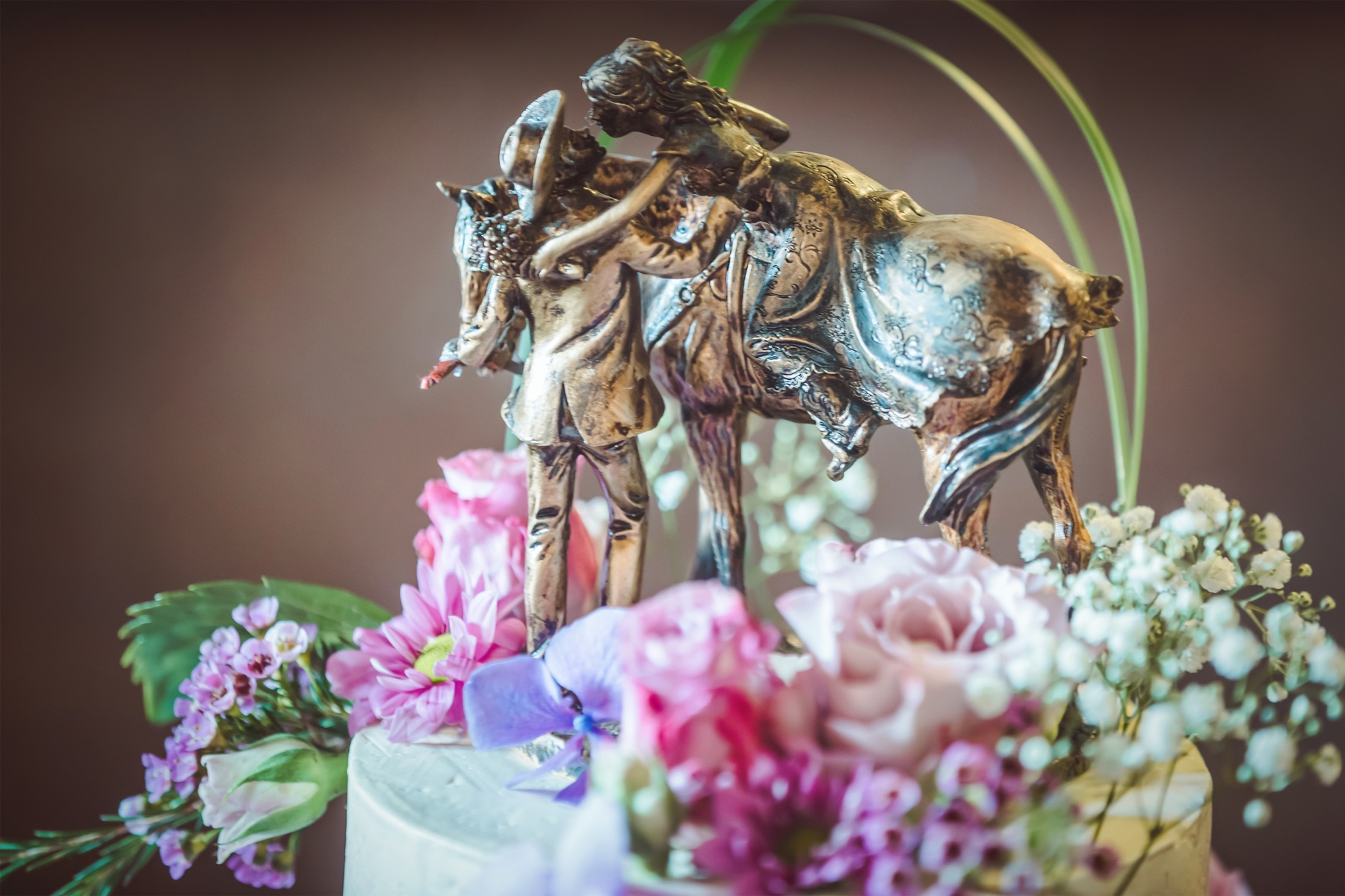 Hochzeitstorte mit Tortenfigur: Brautpaar mit Pferd